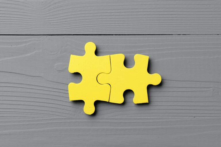 Yellow puzzle pieces on gray background close up